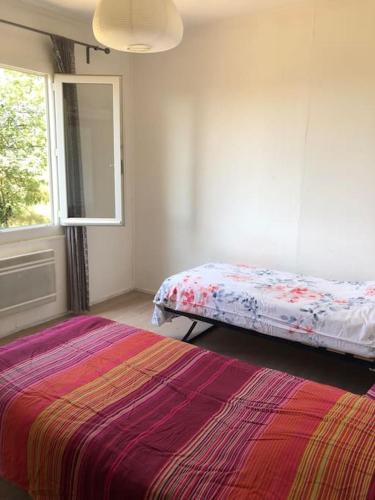 une chambre avec deux lits et une fenêtre dans l'établissement Maison paisible cœur du Ventoux, à Puyméras