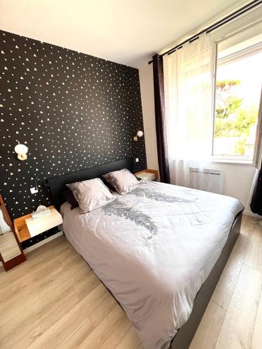 - une chambre avec un lit doté d'un mur en point de polka dans l'établissement Appartement Calme en Plein Centre Ville, à Marseille