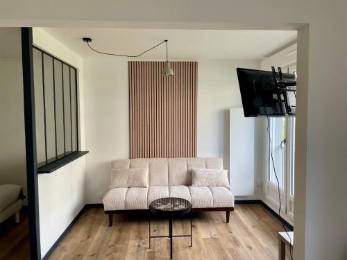 a living room with a couch and a tv at Chez Joe, centre-ville in Verdun