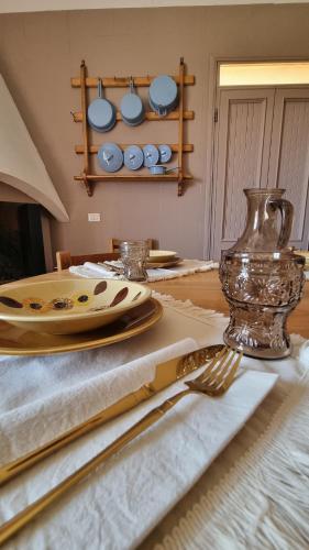 a table with plates and utensils and a vase at Podere Muracciolo in Tuscania