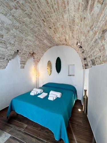 Un dormitorio con una cama azul con techo de piedra. en HOME 5 - Palmento, en Putignano