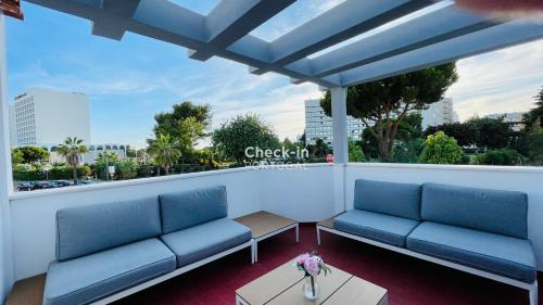 a balcony with blue benches and a view of a city at Neridas Villa - Near the beach - 10 Pax - Quarteira in Quarteira