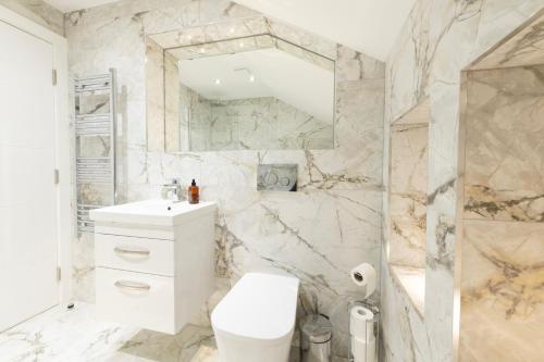 a white bathroom with a toilet and a sink at Modern Morris Mews - High Spec - 7 Guests in Abingdon
