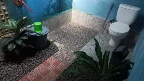 a bathroom with a toilet and plants in it at Brown Bamboo Bukit Lawang Trekking in Bukit Lawang