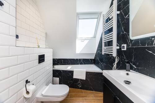 a black and white bathroom with a toilet and a sink at Czorsztyn- Kluszkowce Lake & Ski in Kluszkowce