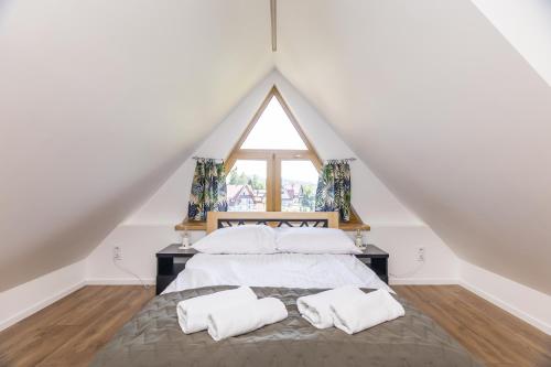 a bedroom with a bed with two pillows and a window at Czorsztyn- Kluszkowce Lake & Ski in Kluszkowce