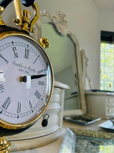 a clock sitting on a table in front of a mirror at Sneaton Castle in Whitby