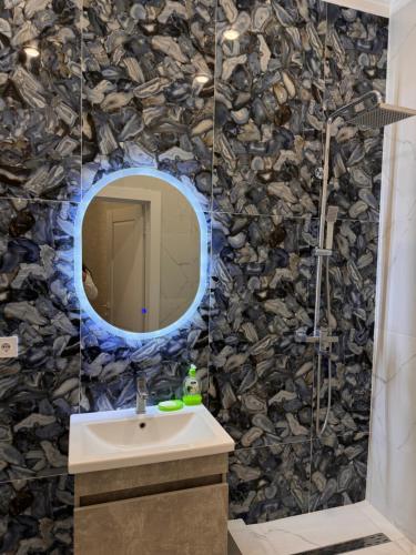 a bathroom with a sink and a mirror at Dastur in Taldykolʼ