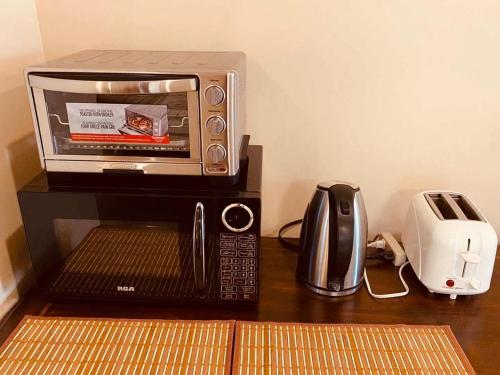a microwave and toaster on a table with a toaster and a printer at 海岛民宿 3张床-2间卧室独立空间套房 in Nanaimo