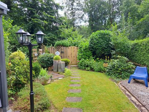 a garden with a light pole and a blue chair at De groene oase de Boschberg in Biddinghuizen