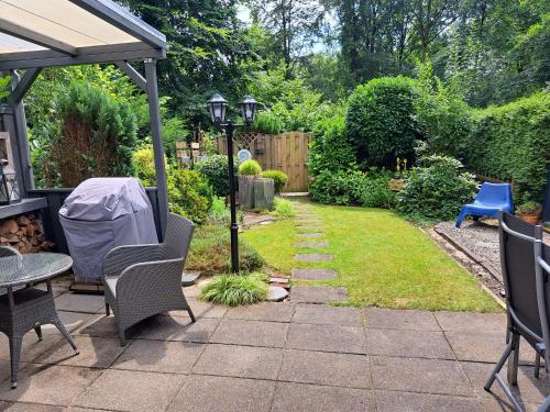 a garden with a patio with chairs and a table at De groene oase de Boschberg in Biddinghuizen