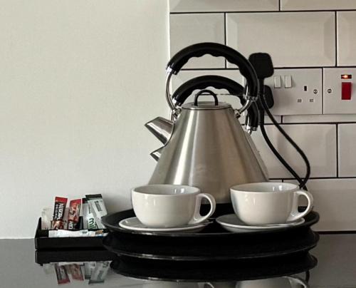 a tea kettle and two cups on a tray at Studio in bolton town, Short stay studio 1 in Bolton