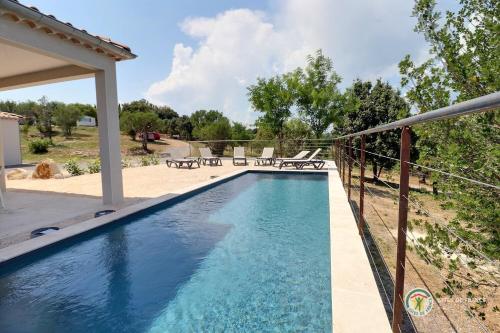 - une piscine à côté d'une maison avec une clôture dans l'établissement Les Villas du Soleil, à Saint Alban Auriolles