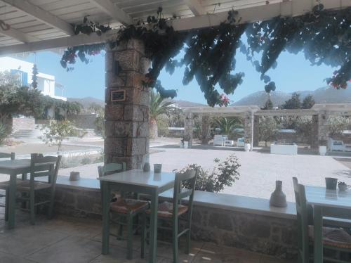 a restaurant with tables and chairs and a patio at Villa Le Grand Bleu in Katapola