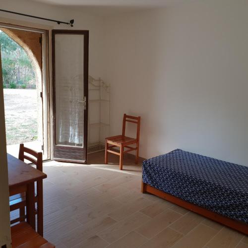 une chambre avec un lit, une chaise et une fenêtre dans l'établissement Résidence Palmarella, à Galéria