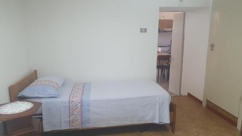 a small bedroom with a bed and a table at A Casa di Mamma in Pescosansonesco