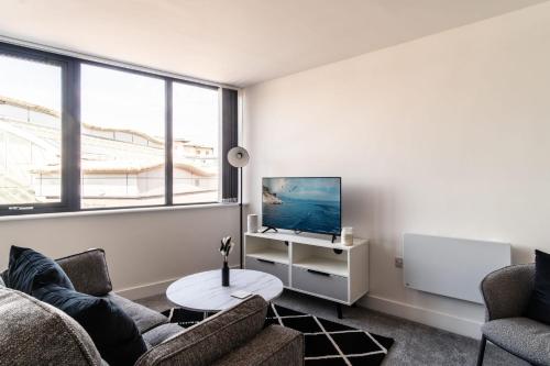 a living room with two couches and a tv at Bright 1 Bed Apartment in Central Wrexham in Wrexham