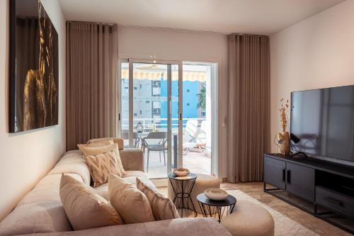 un salon avec un canapé et une télévision dans l'établissement Aquamarina I Calpe, apartement by the beach, à Calp