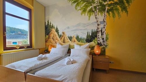 two beds in a room with a painting on the wall at Pension Weiße Rose, Parkplatz, Frühstück, Wlan, Zentral in Bad Elster