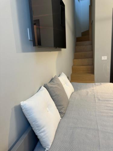 a bedroom with a bed with a flat screen tv on the wall at SKY LUXURY Rooms Nettuno in Nettuno