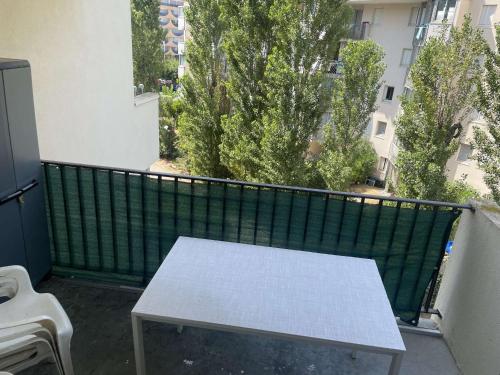 une table sur un balcon avec une clôture verte dans l'établissement Studio avec parking privé, au Grau-du-Roi