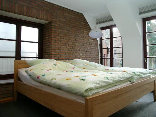 a large bed in a room with a brick wall at Ferienwohnung Am Dom in Xanten