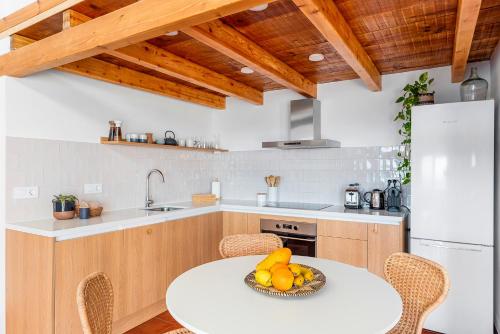 a kitchen with a table with fruit on it at Luminous loft apartment next to the Atlantic Ocean in Radazul
