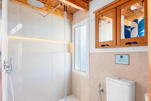 a bathroom with a toilet and a glass shower at Luminous loft apartment next to the Atlantic Ocean in Radazul