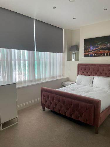 a bedroom with a large bed and a large window at Queen Street Quayside Apartment, NE1 Grade 2 Listed in Newcastle upon Tyne