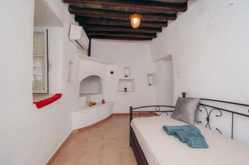 a bedroom with white walls and a bed in a room at Rena's Dream in Artemonas