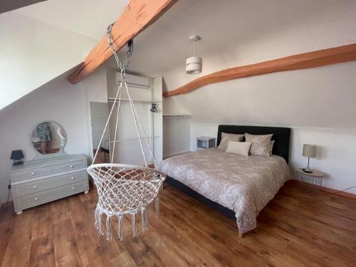 ein Schlafzimmer mit einem Bett und einer Schaukel in der Unterkunft Charmante maison tourangelle proche Amboise in Mosnes