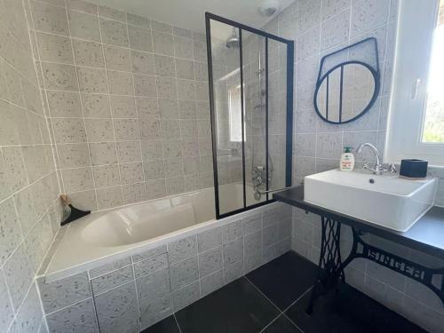 ein Badezimmer mit Waschbecken und Badewanne und Waschbecken in der Unterkunft Charmante maison tourangelle proche Amboise in Mosnes