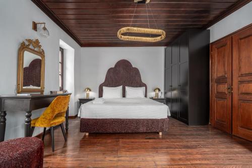 a bedroom with a bed and a desk and a mirror at Telegraphus Boutique Home in Skiathos