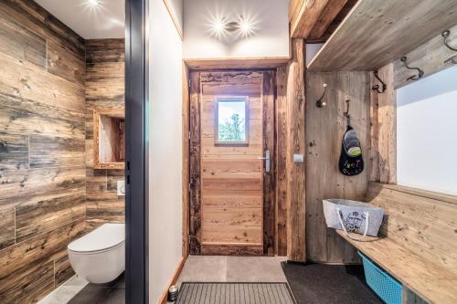 bagno con servizi igienici e pareti in legno di Chalet La Glière de l'Etelley a Samoëns