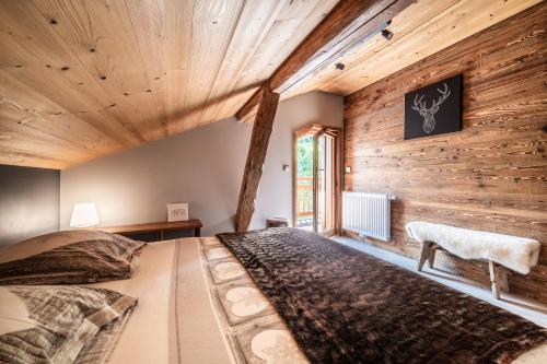 una camera da letto con un letto e una parete di legno di Chalet La Glière de l'Etelley a Samoëns