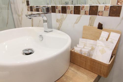 a bathroom with a sink and a basket of toiletries at AuRoom in Naples