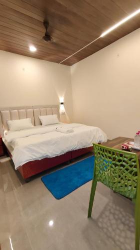 a bedroom with a large bed and a green chair at Sunrise Homestay Agra Near Taj Mahal in Agra