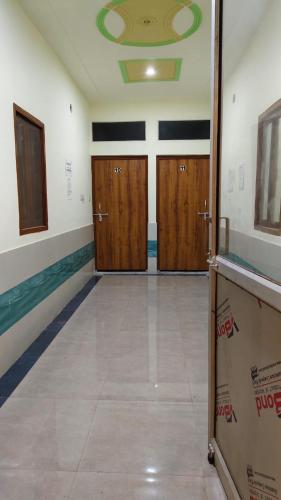a hallway with three wooden doors in a room at Sunrise Homestay Agra Near Taj Mahal in Agra