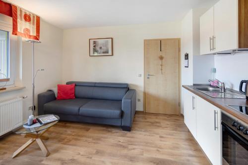 a living room with a blue couch in a kitchen at Ferienwohnung Wiesenschneiders in Freiensteinau
