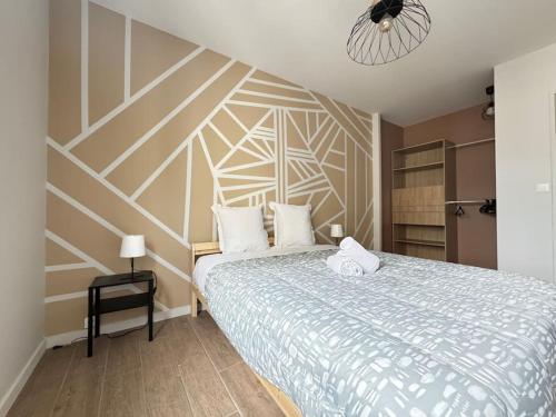 - une chambre dotée d'un lit avec un mur géométrique dans l'établissement Jolie F3 Berthelot , Tout Equipé - WI-FI , CL-FD Berthelot 10eme, à Clermont-Ferrand