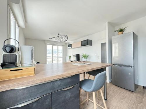 Il comprend une cuisine équipée d'un comptoir en bois et d'un réfrigérateur. dans l'établissement Jolie F3 Berthelot , Tout Equipé - WI-FI , CL-FD Berthelot 10eme, à Clermont-Ferrand