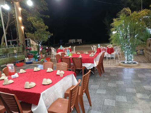 a group of tables and chairs with red table cloths at Quan Lan Nam Phong Hotel in Quan Lạn