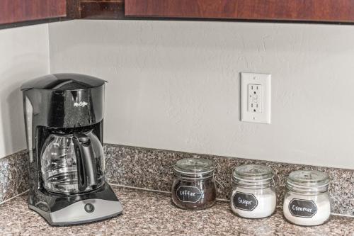 a blender on a counter with two jars of jam at Serene Space with Easy City Access in Salt Lake City