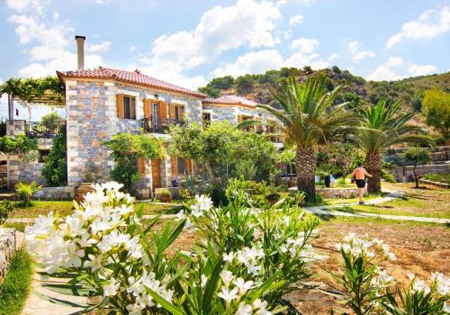a house with palm trees and white flowers at Mani Apartments in Agios Nikolaos