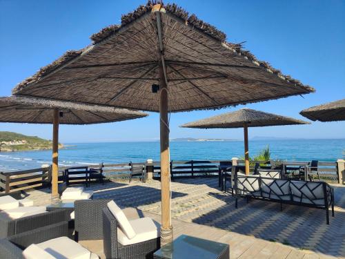 een patio met stoelen en parasols op het strand bij Sea & sun view in Agios Stefanos