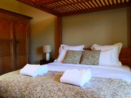 a bedroom with a large bed with white sheets and pillows at Domaine du cloitre in Pléneuf-Val-André