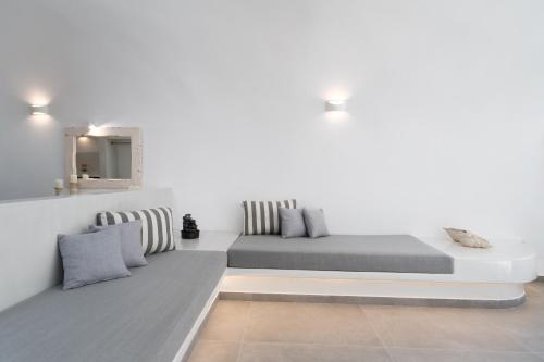 a white room with two beds and a mirror at NEW Yiota Collection 4 Suites & 4 Prive Jacuzzi in Megalokhori
