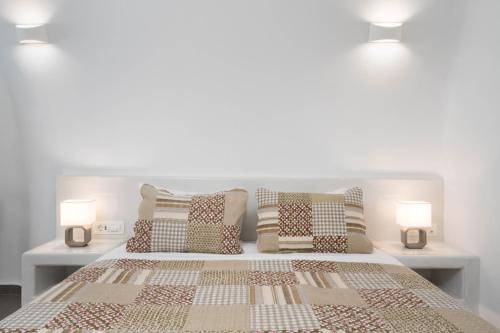 a bedroom with a bed with pillows and two lights at NEW Yiota Collection 4 Suites & 4 Prive Jacuzzi in Megalokhori