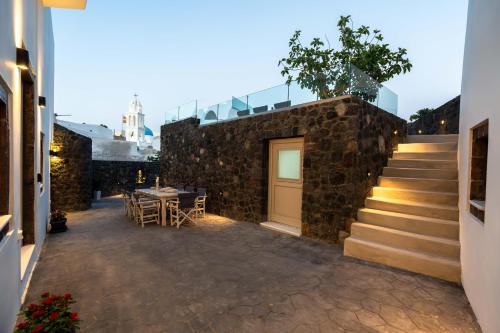 a stone wall with a door and a table and stairs at NEW Yiota Collection 4 Suites & 4 Prive Jacuzzi in Megalokhori