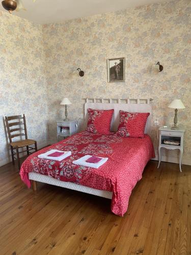 - une chambre avec un lit doté d'un couvre-lit rouge dans l'établissement B&B Chambres d'hôtes Ferme Mahyas, à Saint-Jean-de-Savigny
